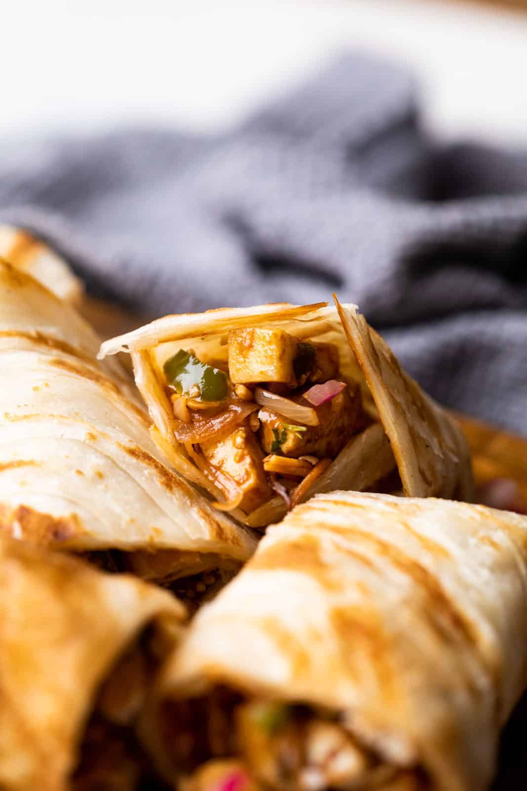 Paneer kathi roll cut into pieces and stacked on top of the other