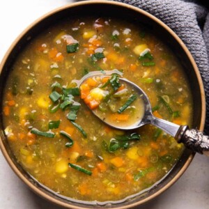 Vegetarian Sweet Corn Soup served in a black bowl with a spoon