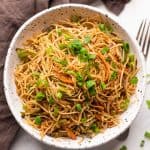 Vegetable hakka noodles served in a white speckled bowl