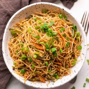 Vegetable hakka noodles served in a white speckled bowl