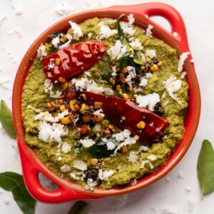 Coconut Coriander Chutney served in a red bowl with tempering on top