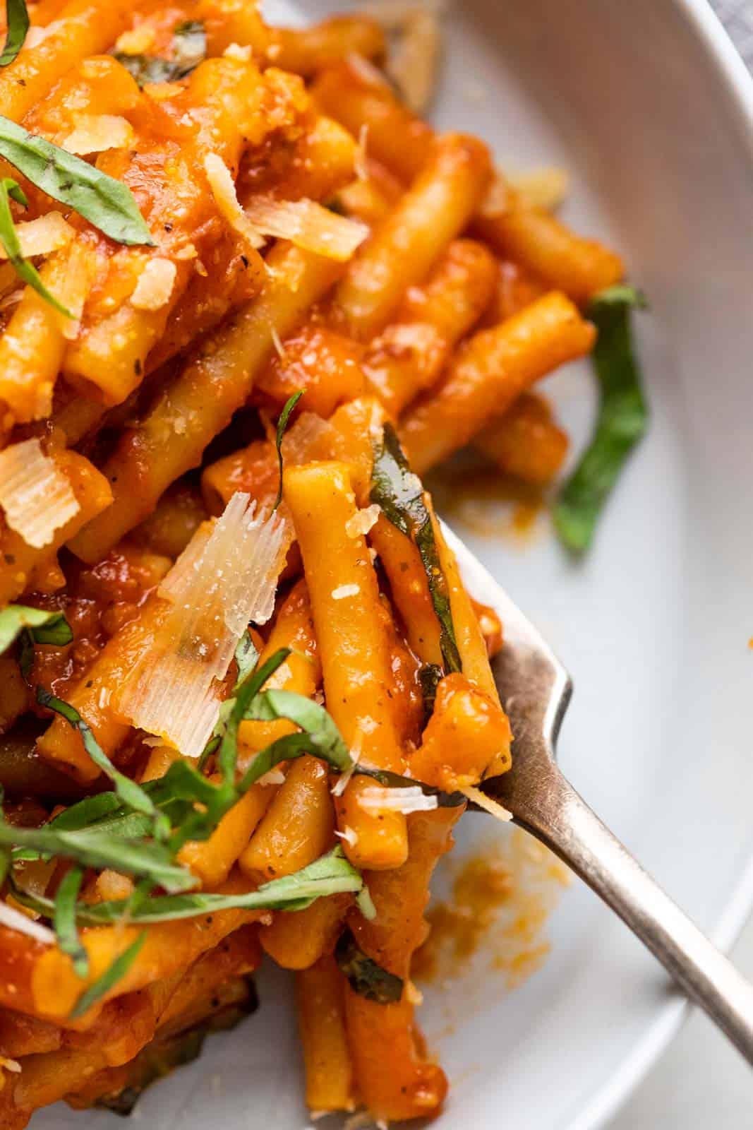 Closeup of instant pot pasta in red sauce being eaten with a fork