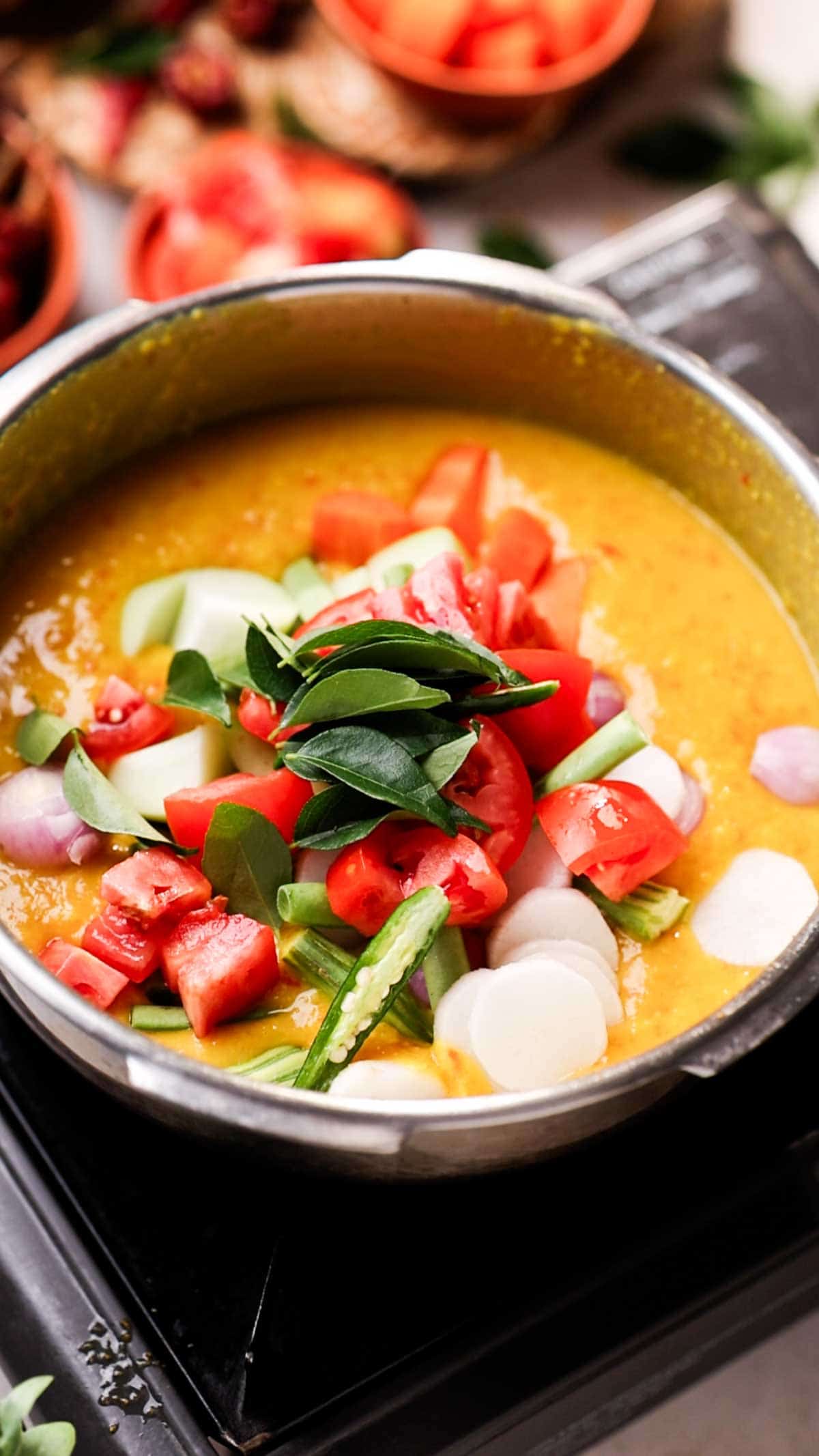 veggies over cooked dal ready to be cooked to make one pot sambar