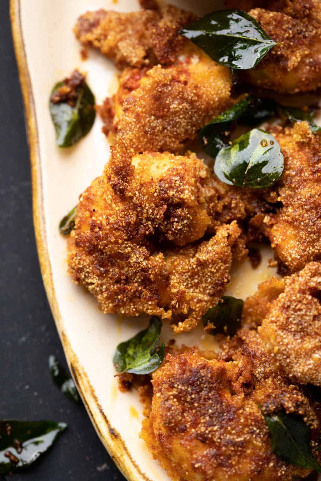 Closeup of prawn rava fry on a beige platter