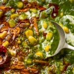 Spoon going into corn palak to show the texture and garlic tadka
