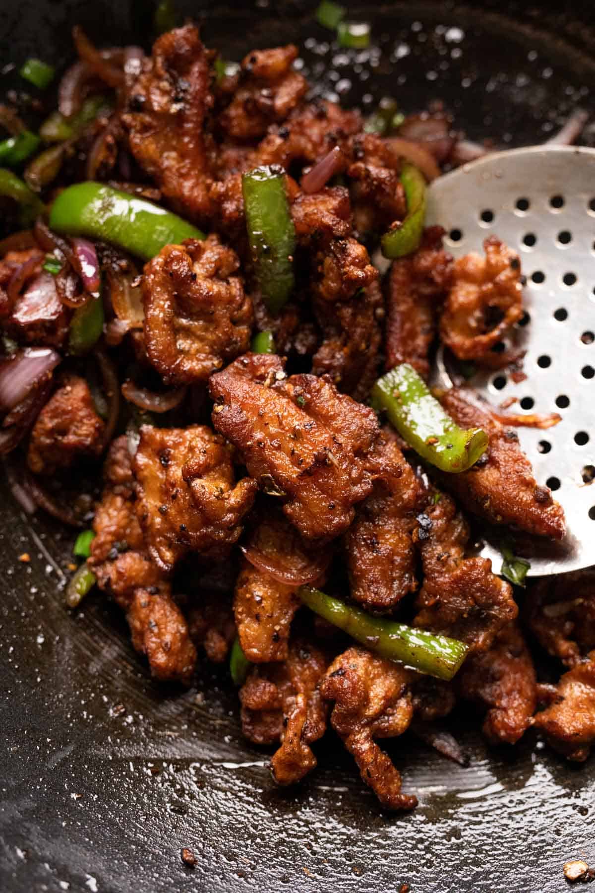 Salt and pepper chicken in the wok after it was stir fried
