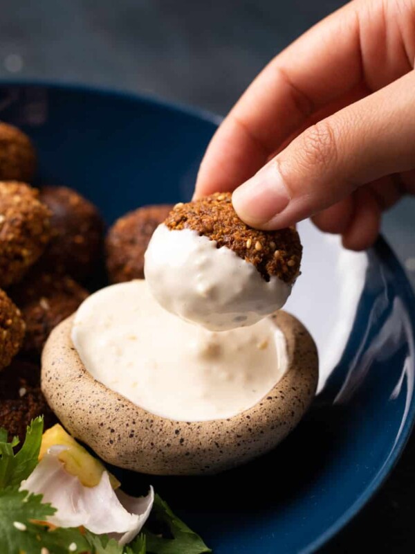 Picture of falafel dipped into tahini sauce