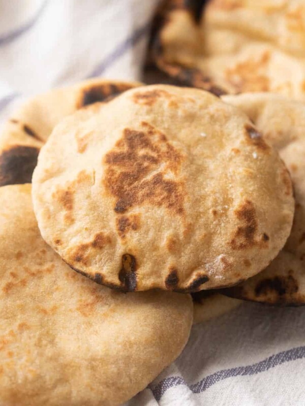 Picture of Whole wheat pita breads kept on a striped white kitchen cloth