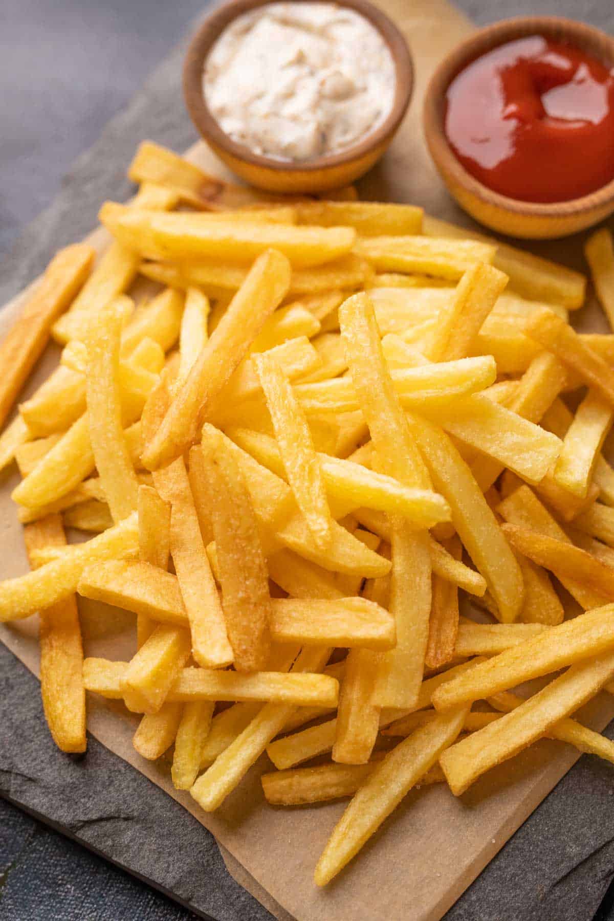 Plate of french fries served with a mayonnaise dip and ketchup