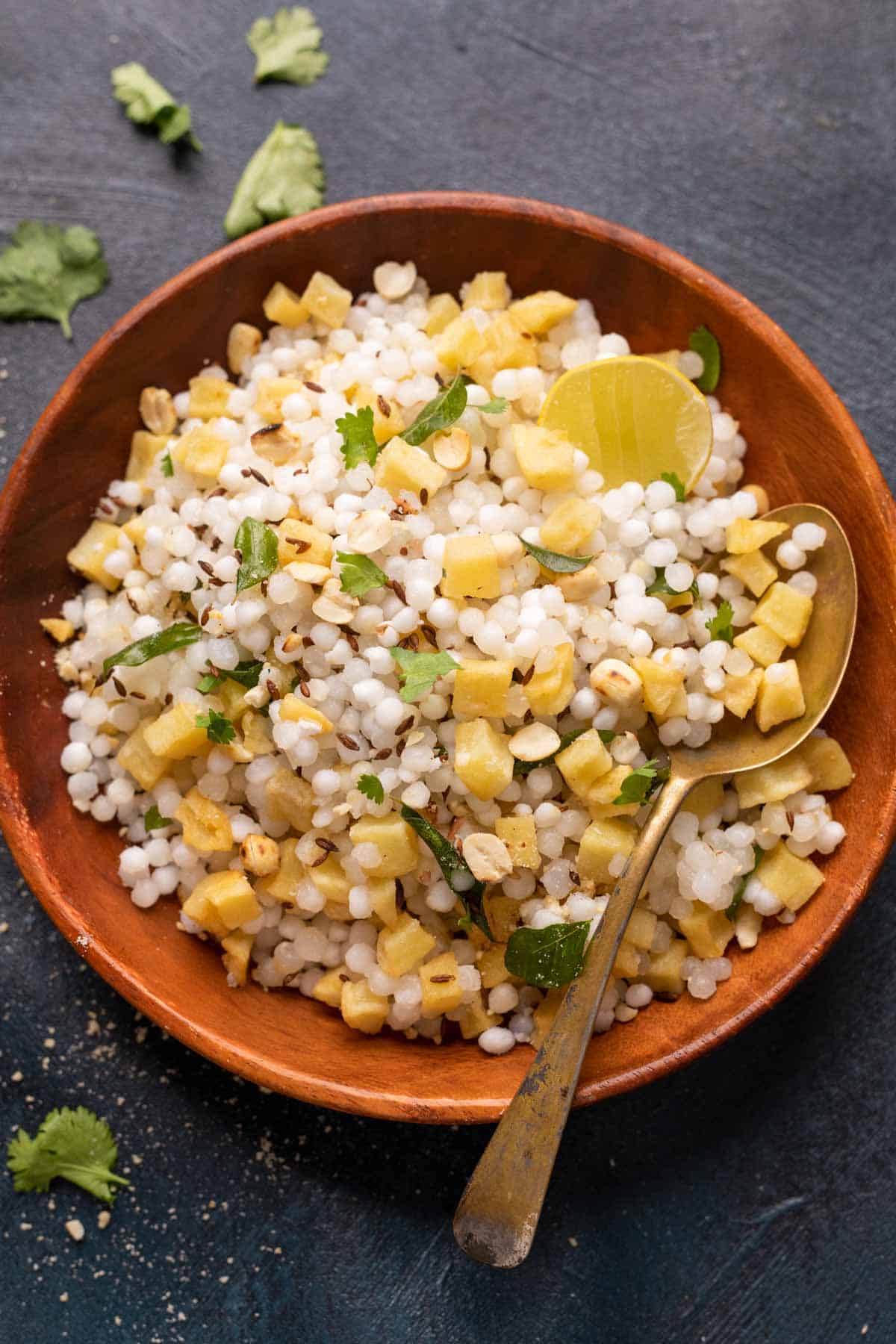 Sabudana khichdi served in a brown bowl with a spoon