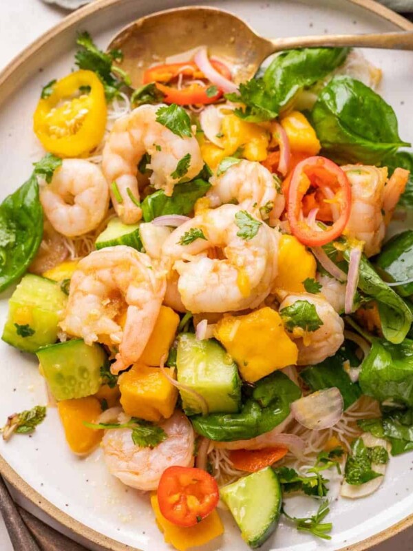 Thai Prawn Mango Salad served on a white plate with cutlery on the side