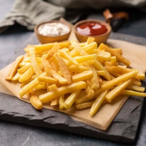Plate of french fries served with a mayonnaise dip and ketchup