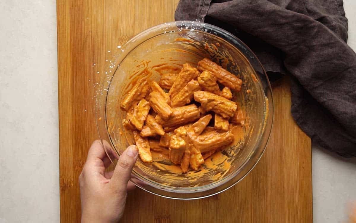 Picture showing how to batter coat baby corn fry