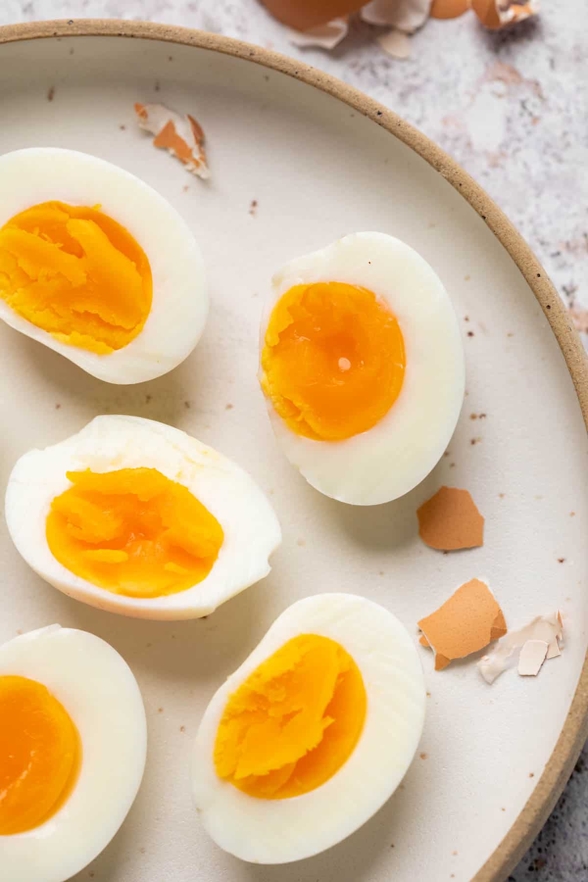 Different varieties of hard boiled eggs placed on a white plate