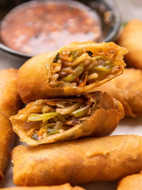 Spring rolls cut in half stacked on top of each other to show the filling and crispy texture