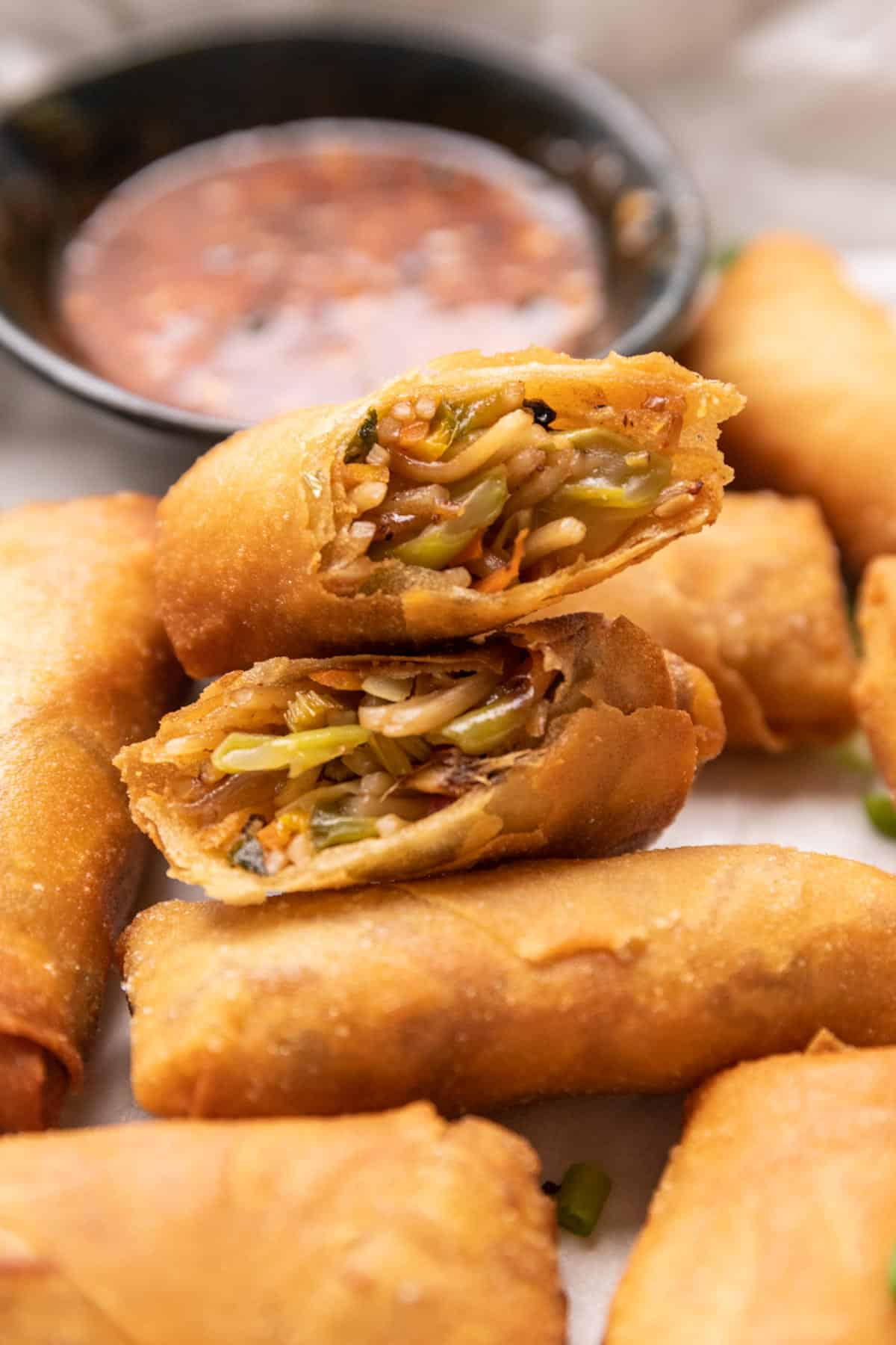 Spring rolls cut in half stacked on top of each other to show the filling and crispy texture