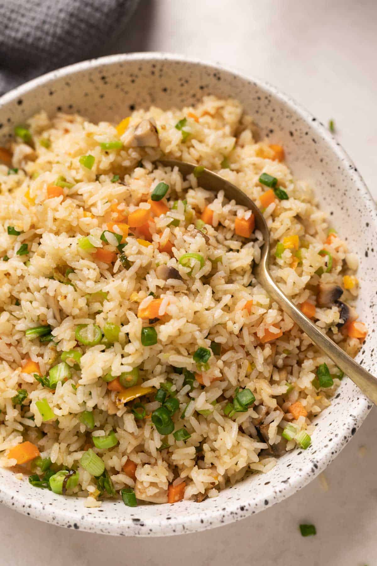 Picture of fried rice in a white bowl with a spoon