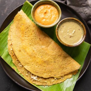 High Protein Dosa served on a banana leaf with chutney and curry on the side