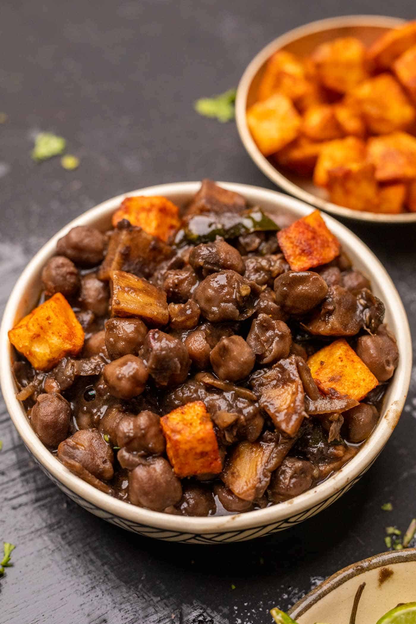 Bowl of pindi chole served with spicy fried aloo