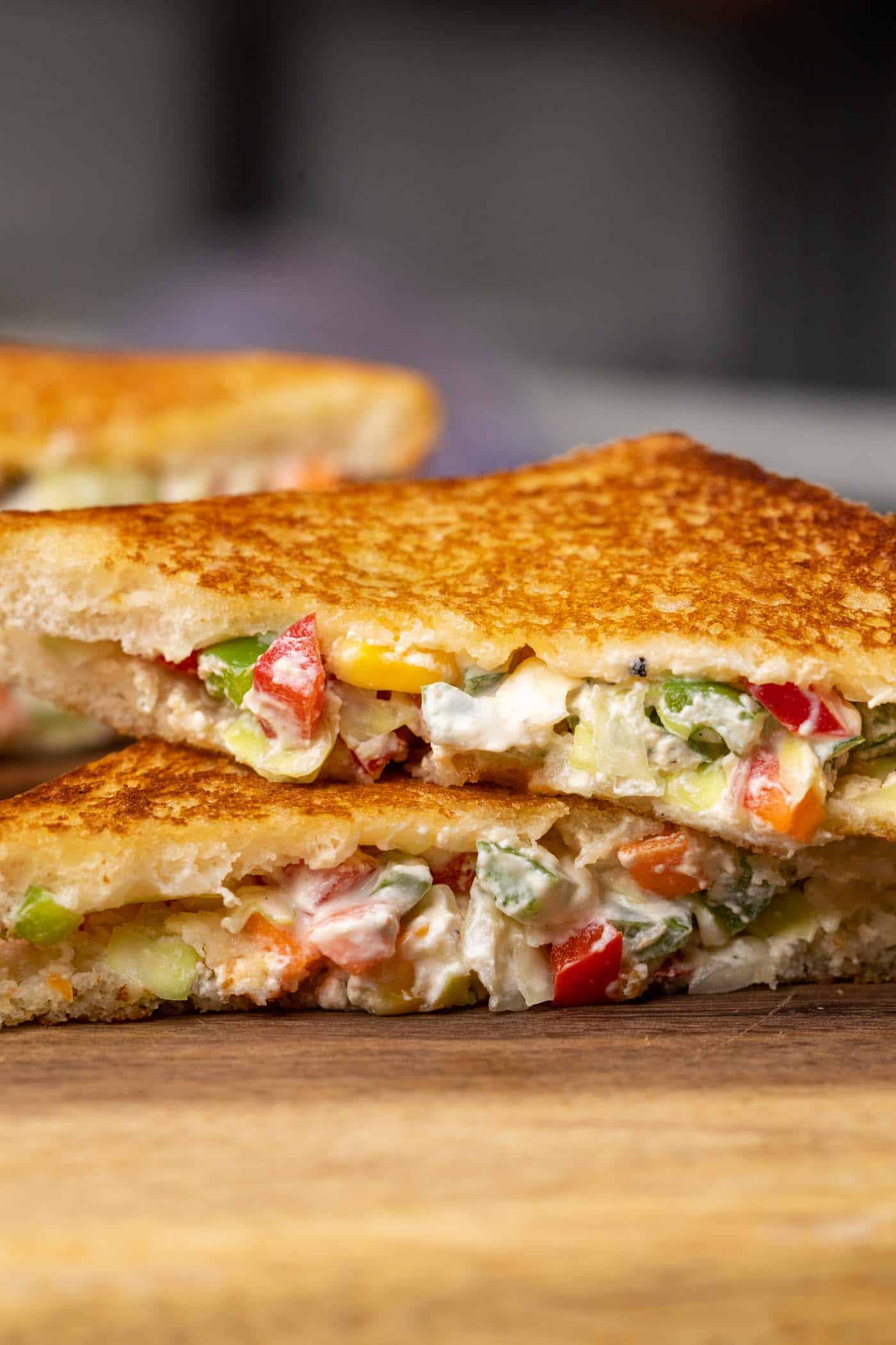 Two hung curd sandwiches sliced and stacked on top of one another
