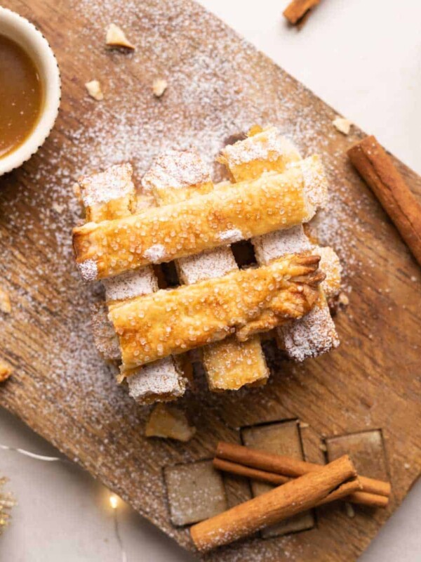 Apple Pie Chips stacked on a wooden board with salted caramel sauce.