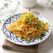 Chinese maggi served in a white and blue plate.