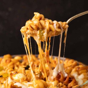 Closeup of air fryer baked pasta in red sauce being eaten with a fork