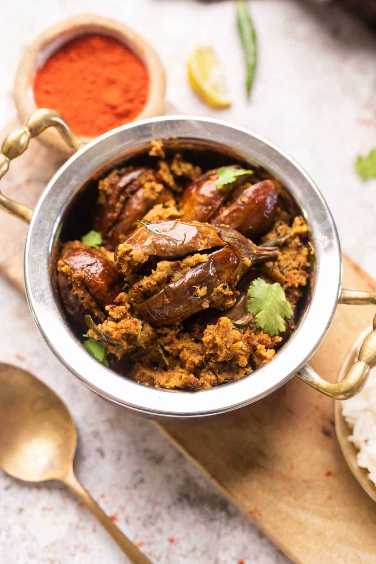 an image of air fryer stuffed brinjal garnished with coriander leaves and served in a handi
