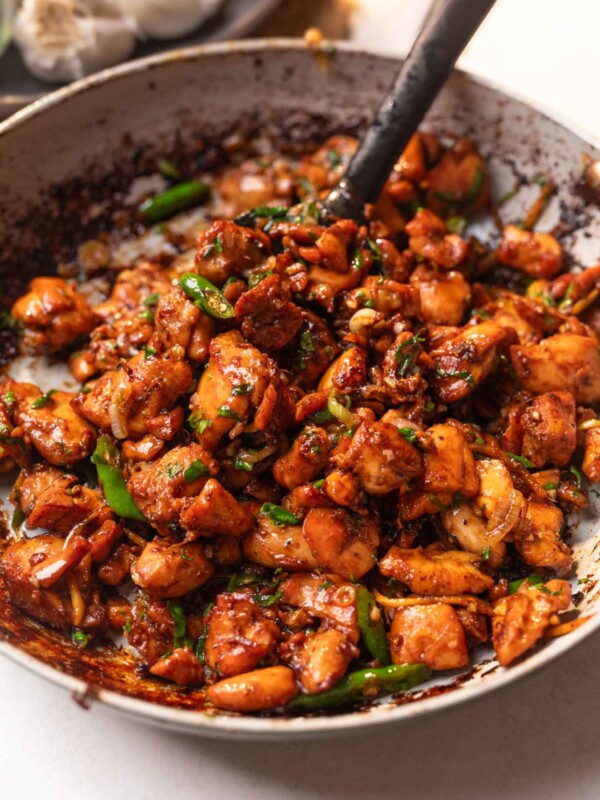 ginger chicken stir fry served over rice, along with a spoon