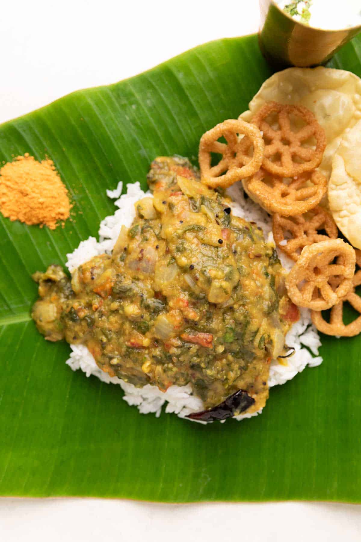 rice served on banana leaf with andhra pappu, with fryums and chutney podi