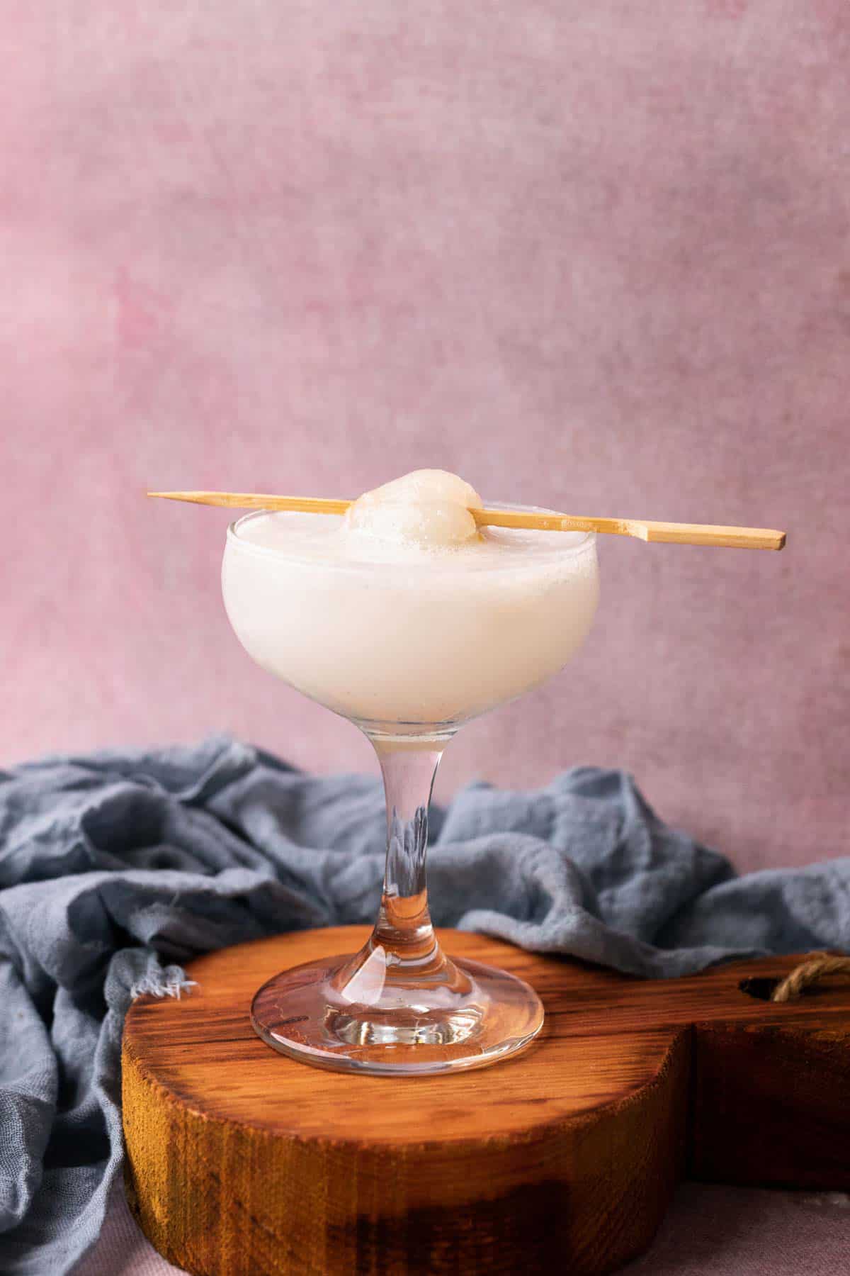 lychee soda served in a glass topped with lychee on a toothpick