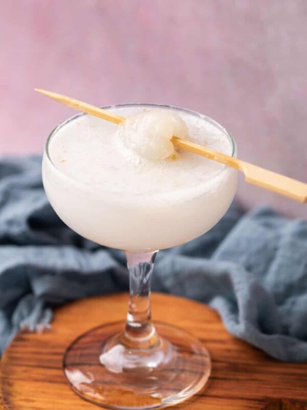 lychee soda served in a glass topped with a lychee on a toothpick