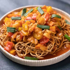 Sweet and Sour Vegetables served on crispy fried noodles in a white plate