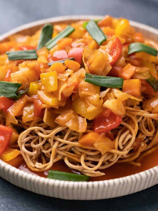 Sweet and Sour Vegetables served on crispy fried noodles in a white plate