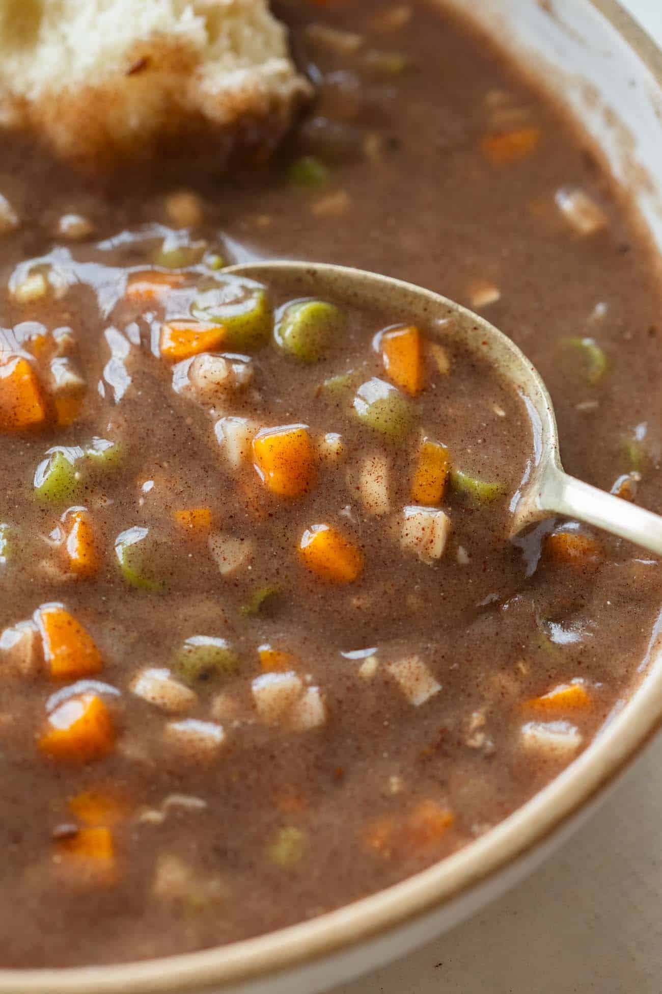 a whole bowl with ragi soup with diced carrots and beans with a spoon