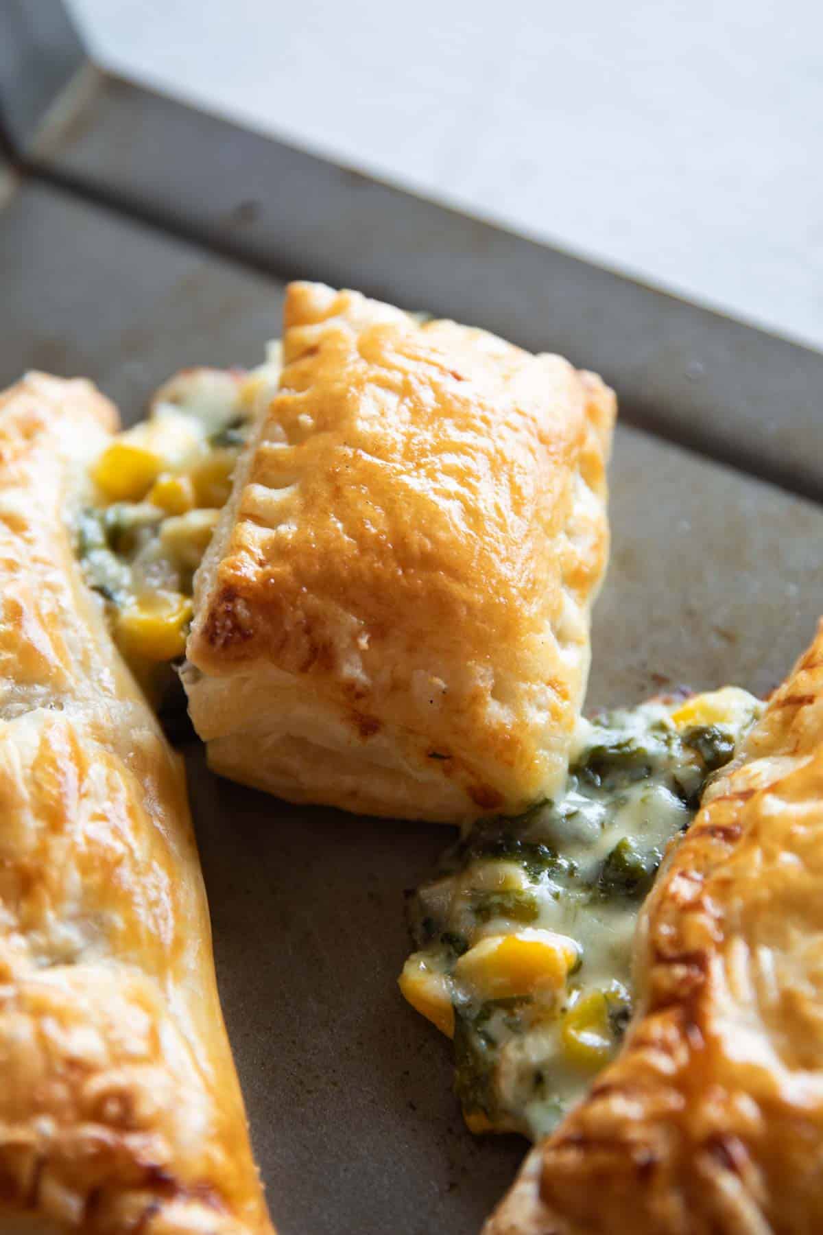 closeup shot of corn spinach puff with the filling oozing out