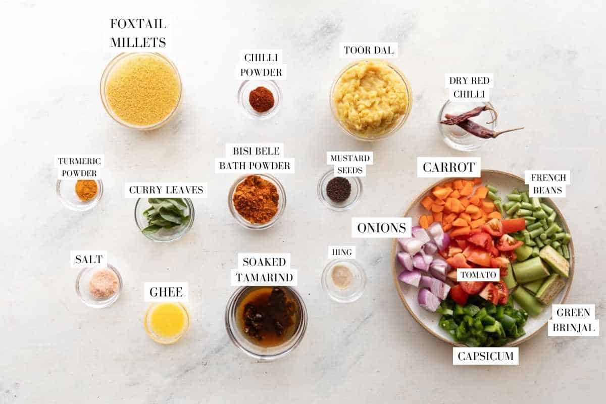 Picture of all the ingredients for Millet Bisi Bele Bath with text to identify them