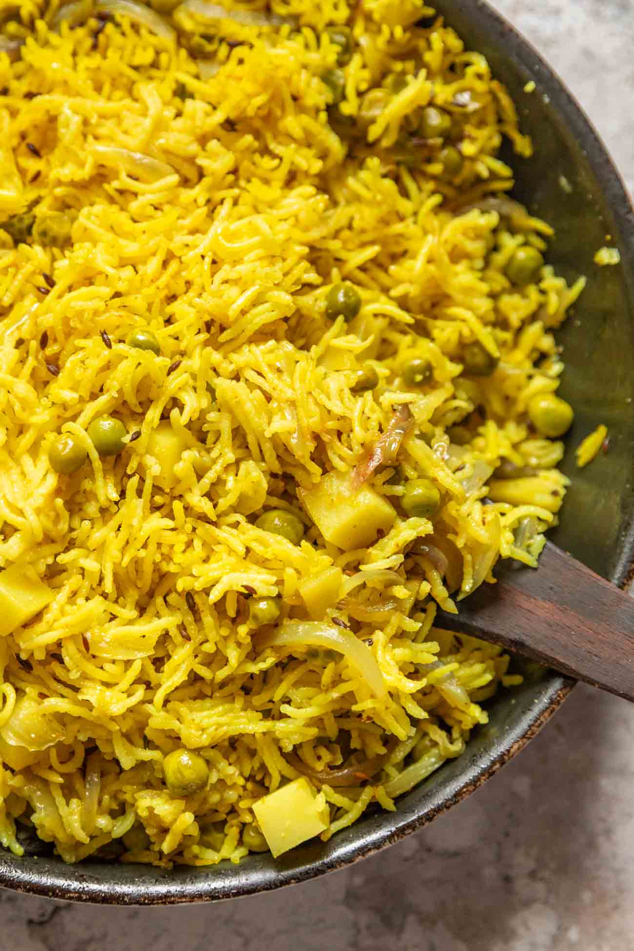 picture of tahari rice in a grey pan with a wooden spoon