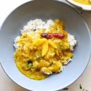 raw mango dal served with rice in a grey bowl