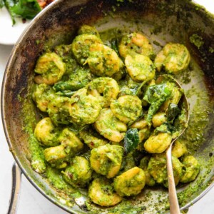 curry leaf prawns in a frying pan with spoon