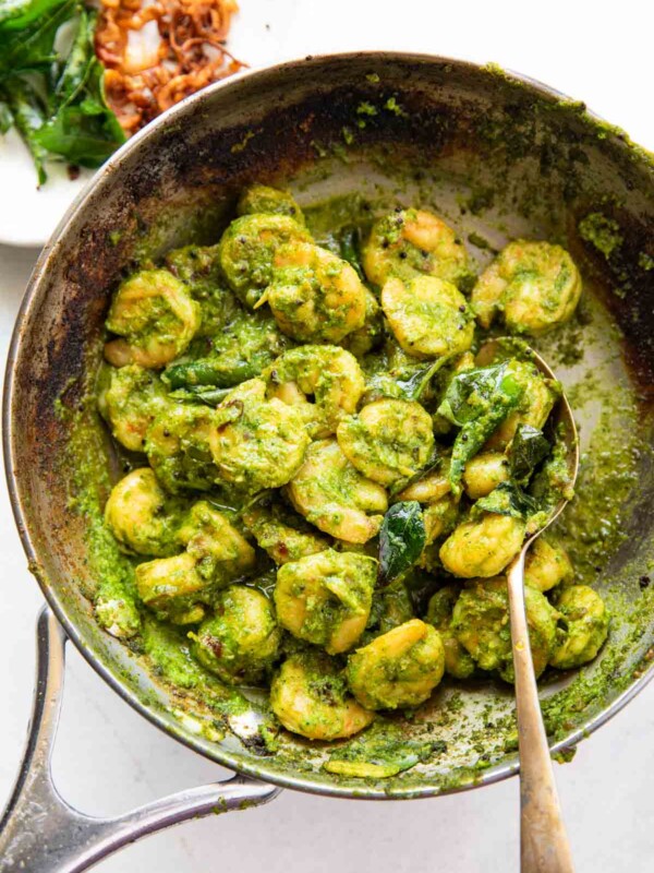 curry leaf prawns in a frying pan with spoon
