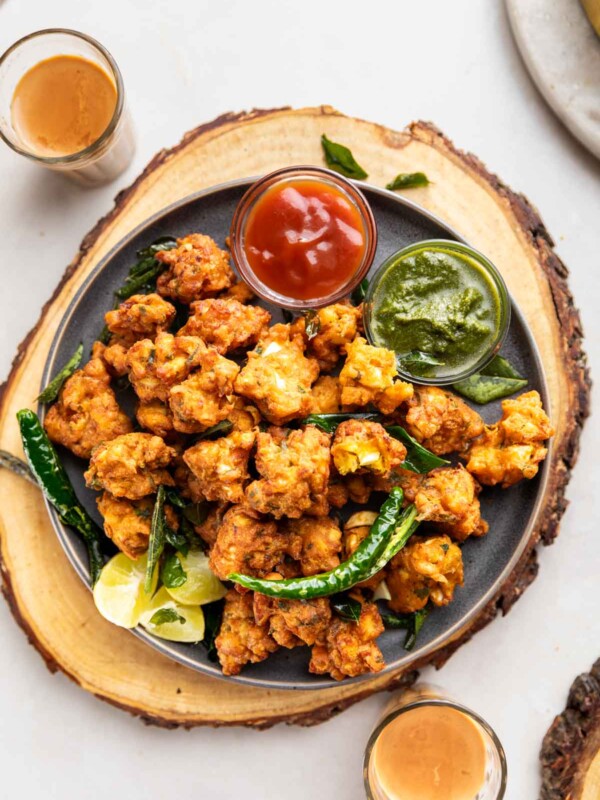 egg pakoda served with green chutney, tomato ketchup, tea fried green chilli and lemon wedges
