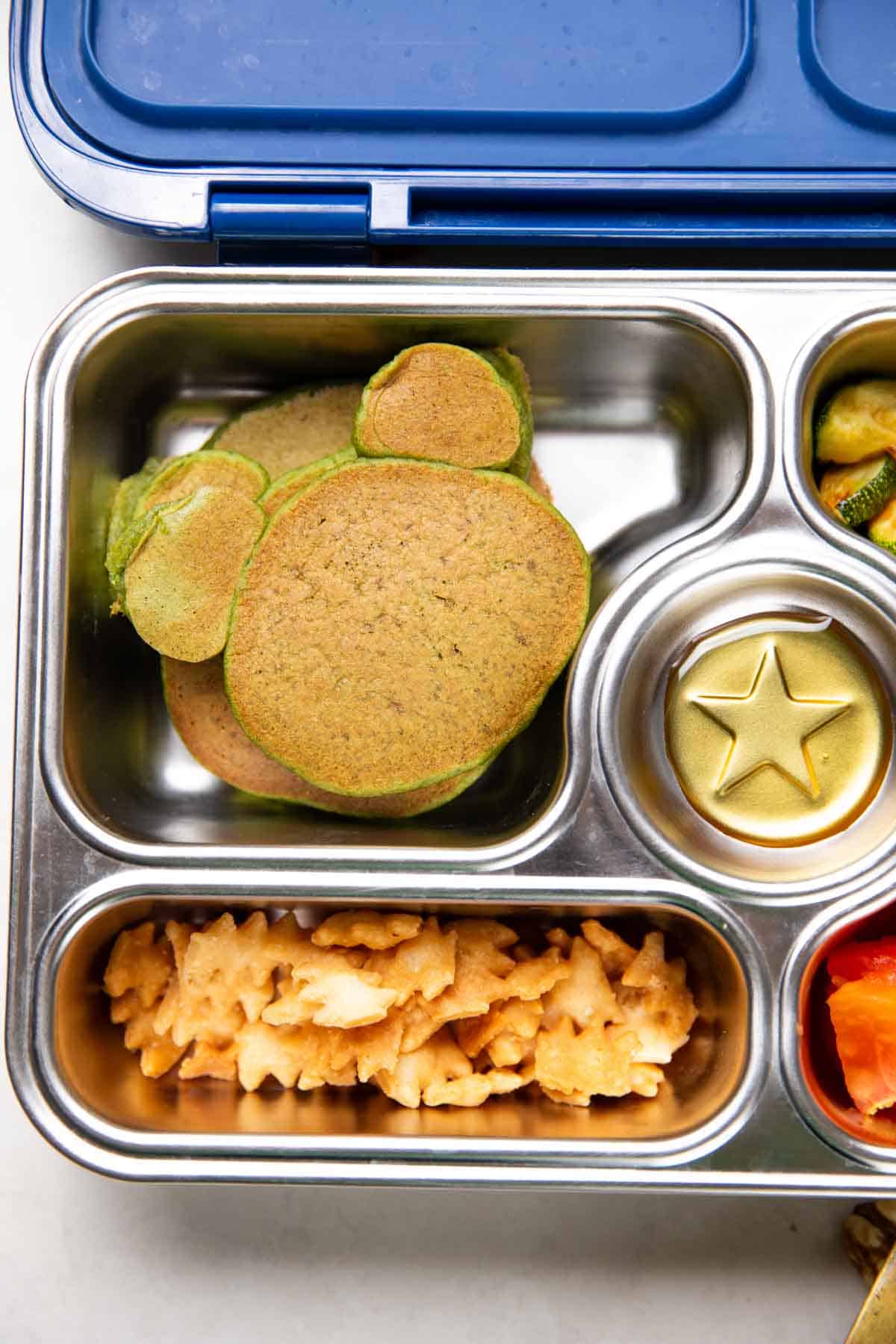 mickey mouse shaped spinach banana pancakes in a tiffin box