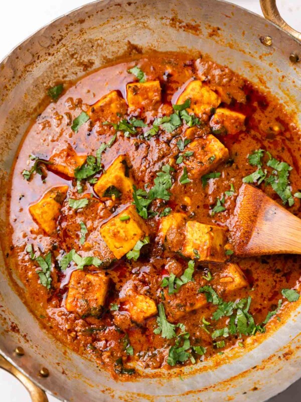 Dhaba style paneer masala in a kadhai with a wooden ladle