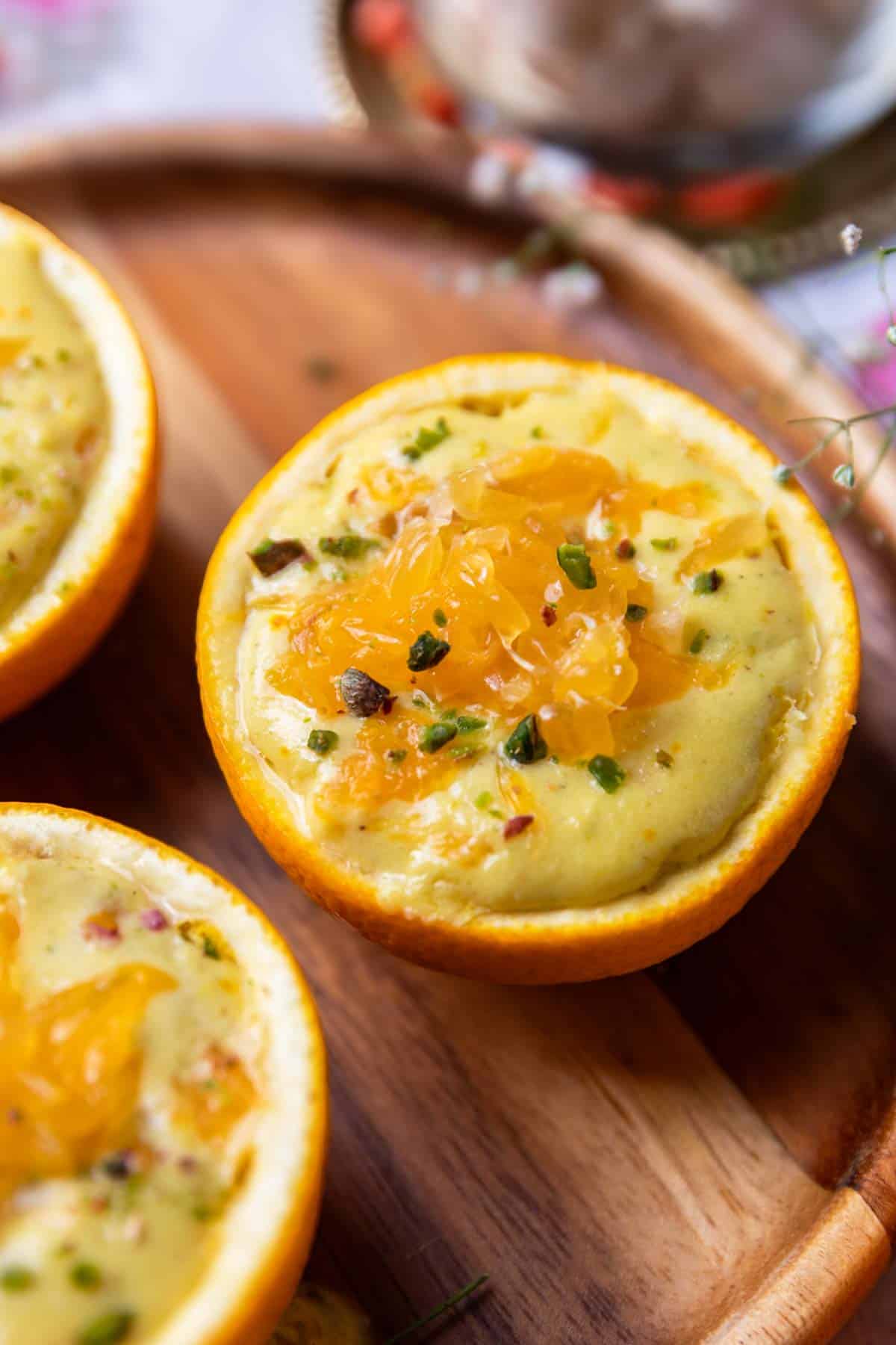 a close up of orange makhana pudding served in orange peel bowls
