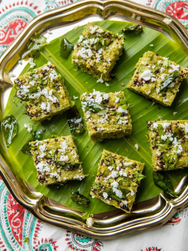 Sprouts dhokla garnished with tempering and served on a leaf platter