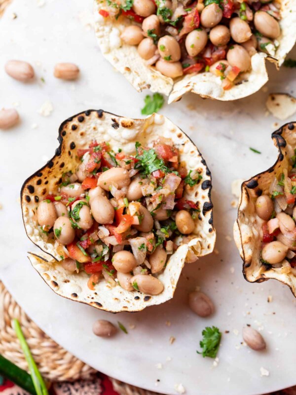 edible papad bowls filled with peanut chaat and served on a white platter