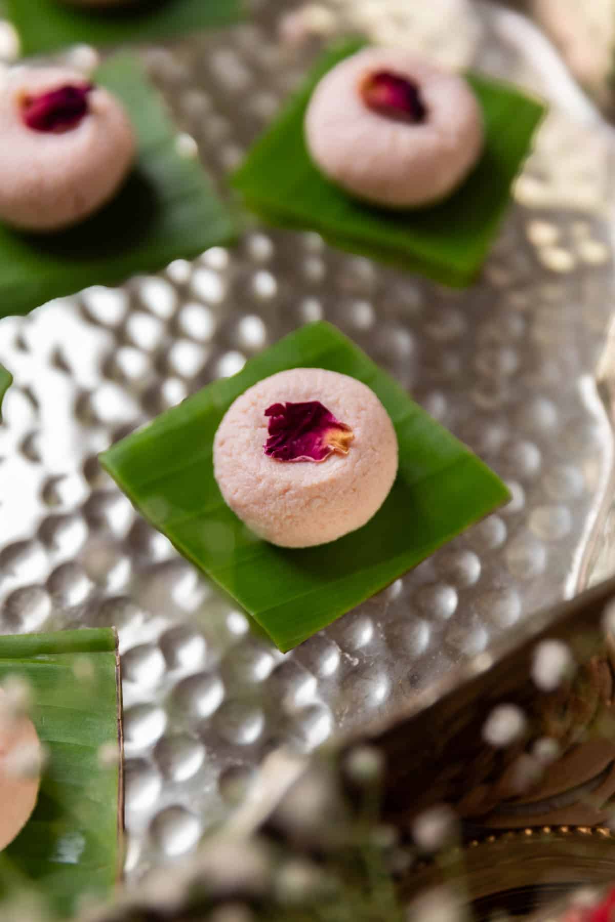 rose kacha golla garnished with dried rose petal and served on a leaf square