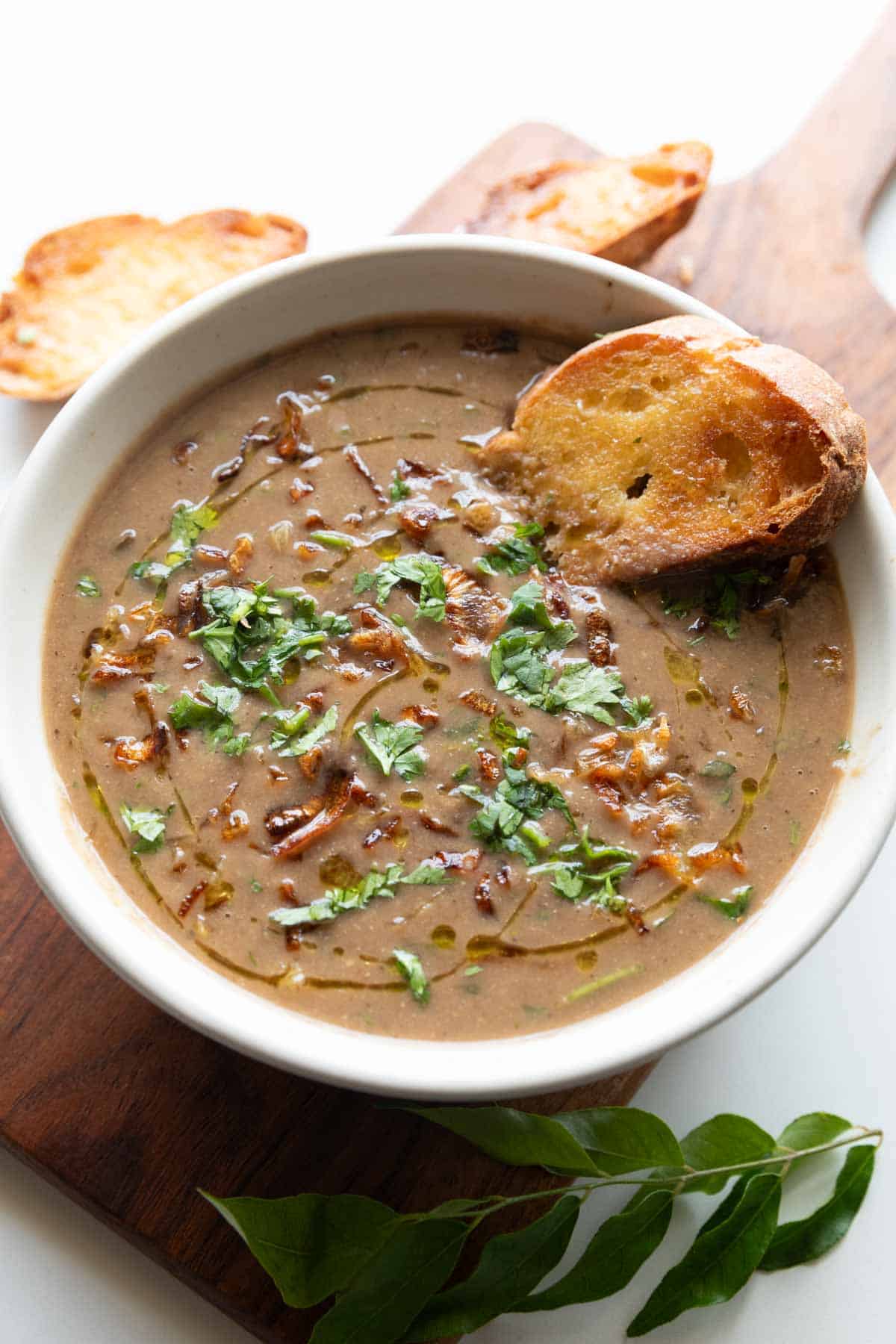 thick & wholesome horse gram soup garnished with birista and coriander, served with bread