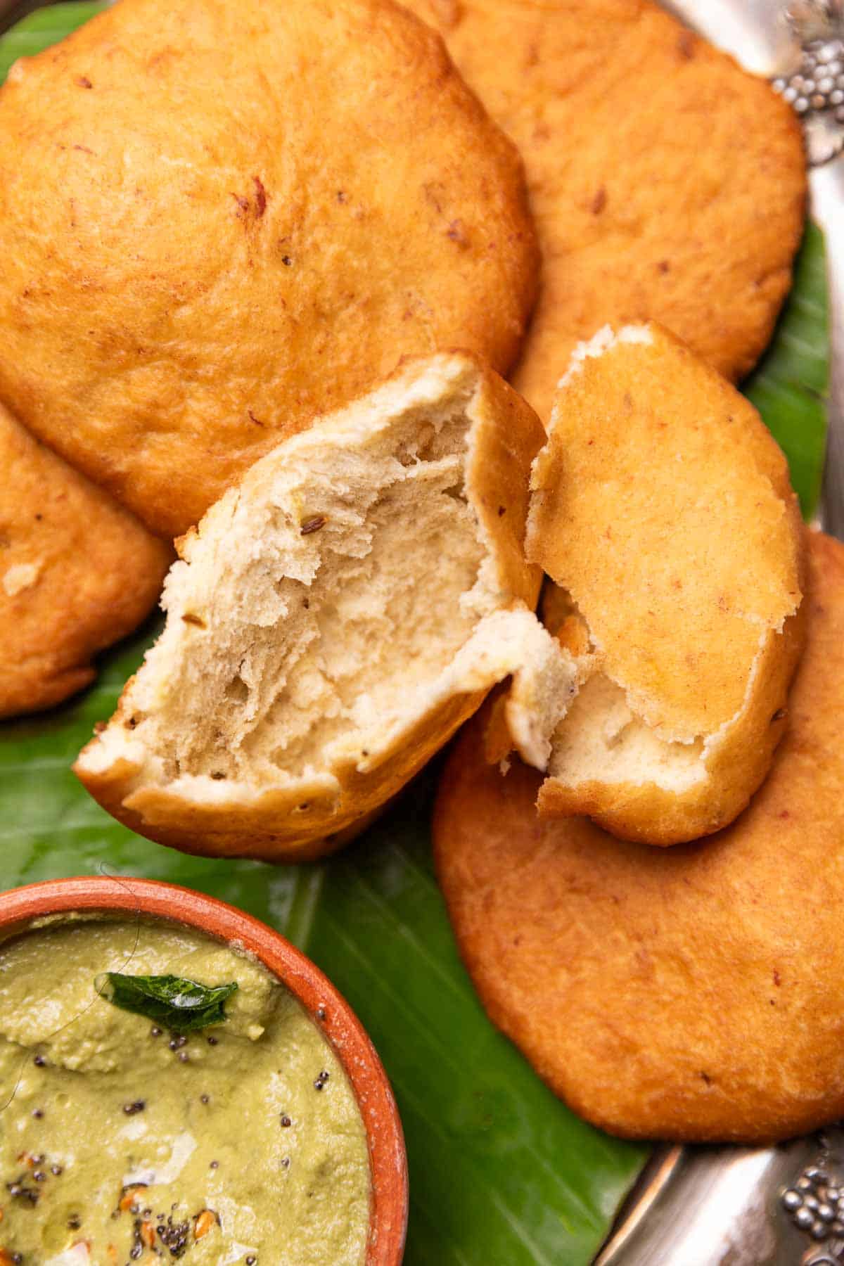 a close up image of mangalore bun broken in half to show the light and airy texture